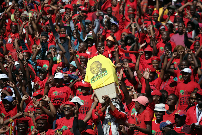 Supporters of the opposition EFF carry a mock coffin bearing the face of the President Cyril Ramaphosa, leader of the ruling ANC.