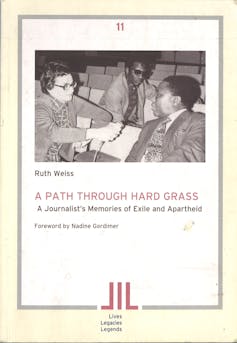 A book cover featuring a woman in spectacles interview a man with another man looking on.