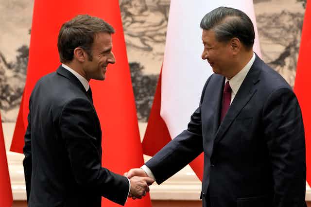 Emmanuel Macron shakes hands with Xi Jonping