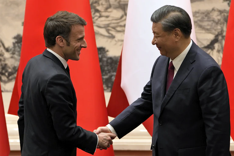 Emmanuel Macron shakes hands with Xi Jonping
