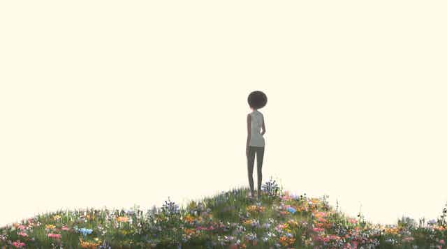 A woman standing alone in a field.