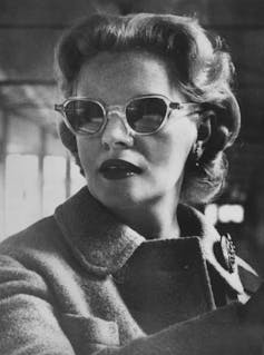 A woman in sunglasses and winter coat.
