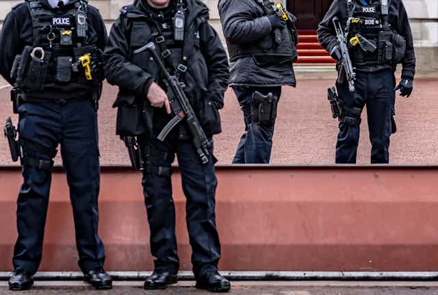 Photo of four London armed police with their faces cropped out of the photo, two holding large firearms