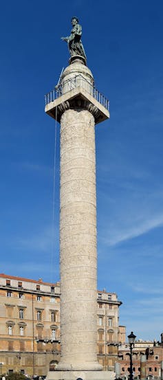 Trajan’s Column in Rome, a tall engraved column with a bronze figure at the top.