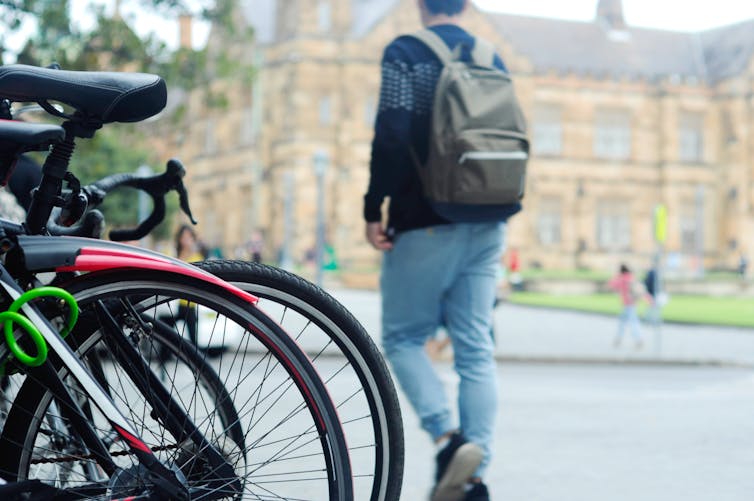 A student walks past a row of bikes at Sydney University.