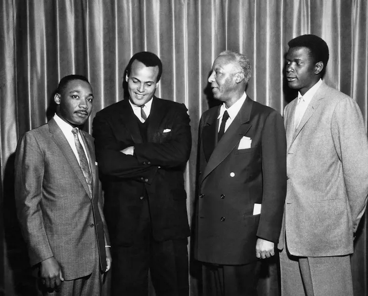 Black and white photograph of four men in suits.