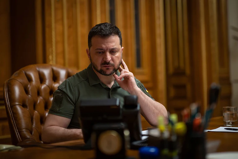 Ukrainian president, Volodymyr Zelensky at his desk on the telephone.