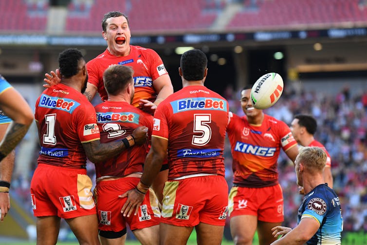 Dolphins NRL players celebrating a try.