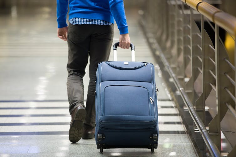A man pulling a suitcase