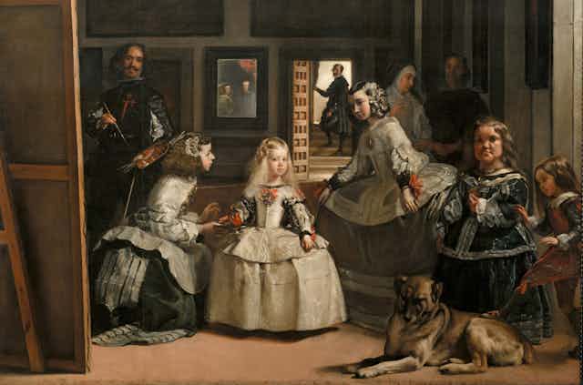 Una niña es atendida por dos damas mientras un pintor la retrata en un óleo de espaldas al espectador.