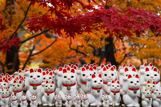 Maneki-neko statues with Autumn Leaves