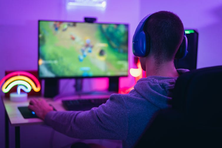 A boy seen in front of video gaming screen.