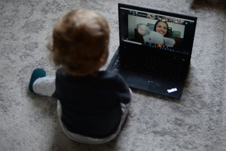 A toddler seen watching a laptop screen.