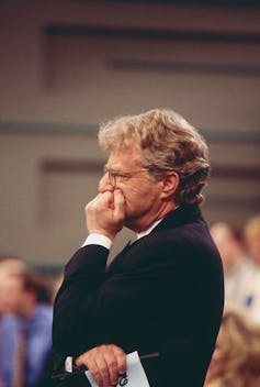 Man holding fist to face looking contemplative.