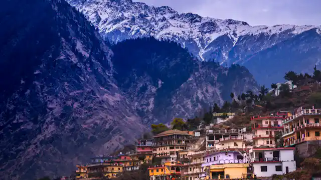 town on hillside, mountain in background