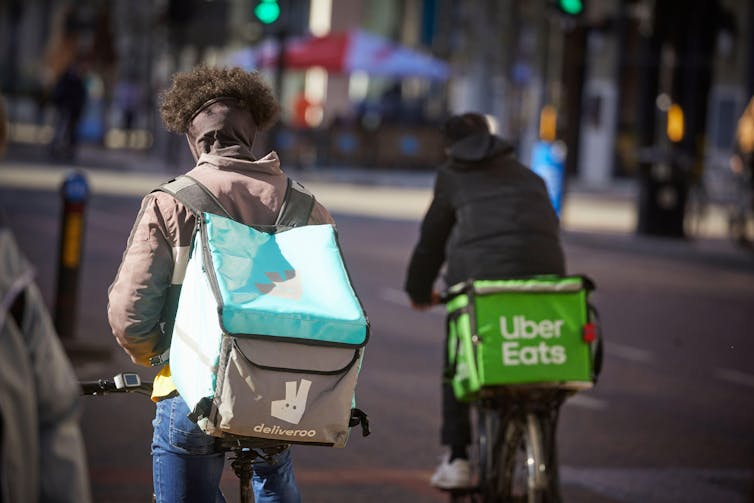 Two food couriers on their bicycles