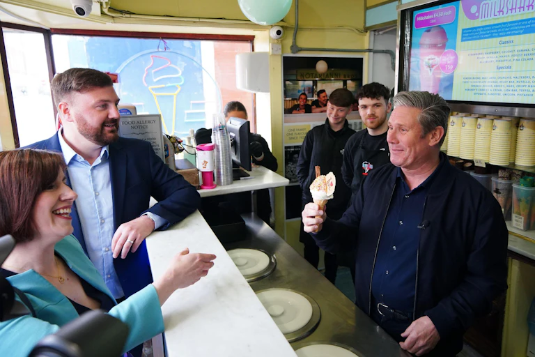 Keir Starmer serving an ice cream to his colleagues at an ice cream parlour.