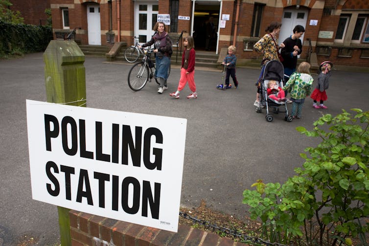 Mothers and children leave their local polling station.