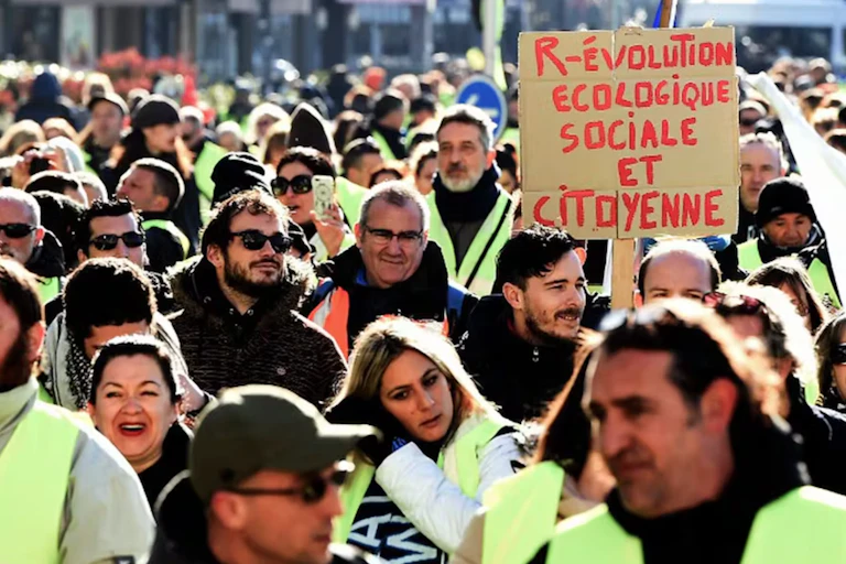 foule de gilets jaunes avec une pancarte révolution écologique sociale et citoyenne