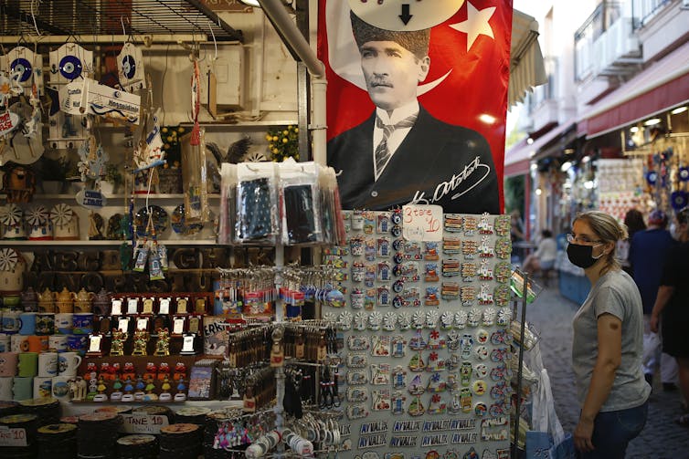 A banner seen showing a man in a suit at a tourist trinket outdoor shop.