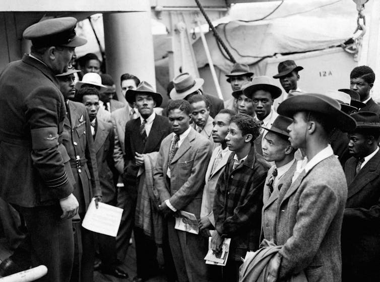 استقبل مسؤولون من مكتب المستعمرات ركاب Windrush في صورة بالأبيض والأسود