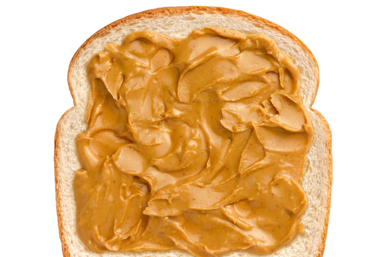peanut butter spread on a piece of white sandwich bread