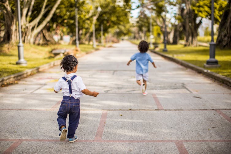 Two children seen running outdoors.