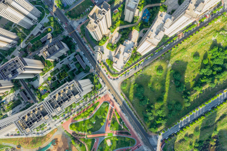 Roads crossing in a city with high-rise towers and parks.