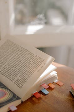 A book with marked by coloured tabs on a table.