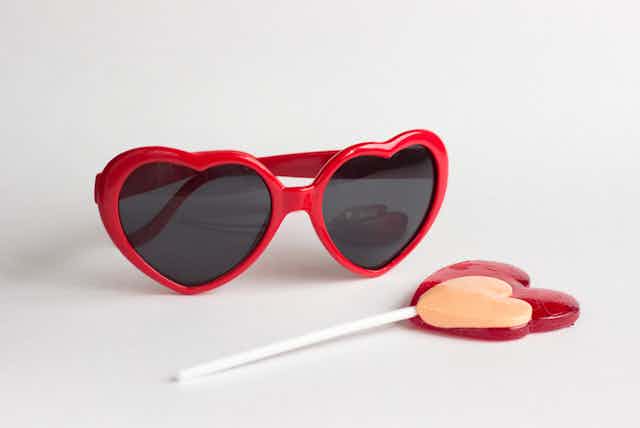 heat-shaped sunglasses and a heart lollipop