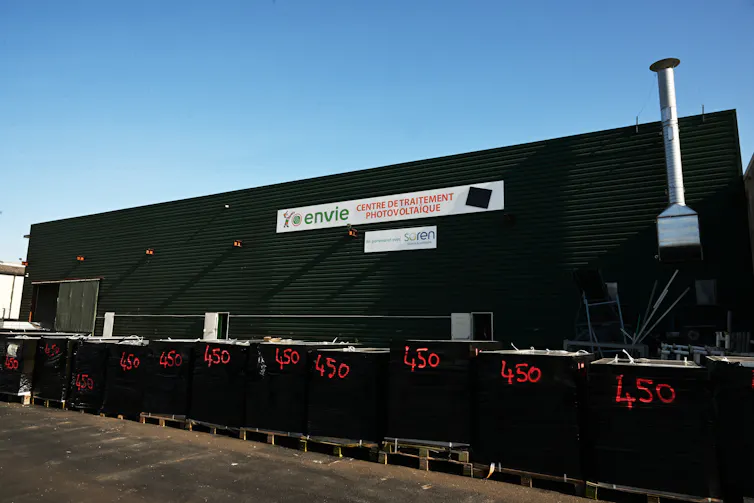piles of solar panels outside a recycling plant