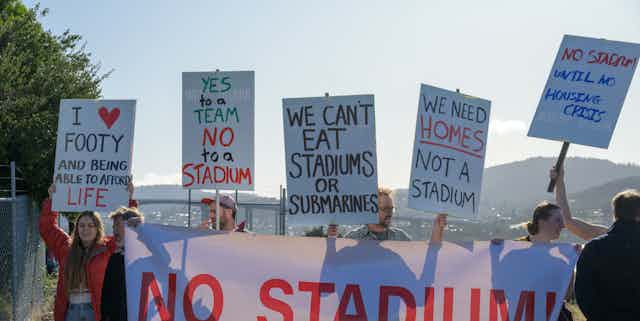 Protestors at press conference in Hobart on Saturday, April 29 2023, at which Prime Minister Anthony Albanese pledged $240 million to help the Tasmanian government build a new waterfront stadium in Hobart.