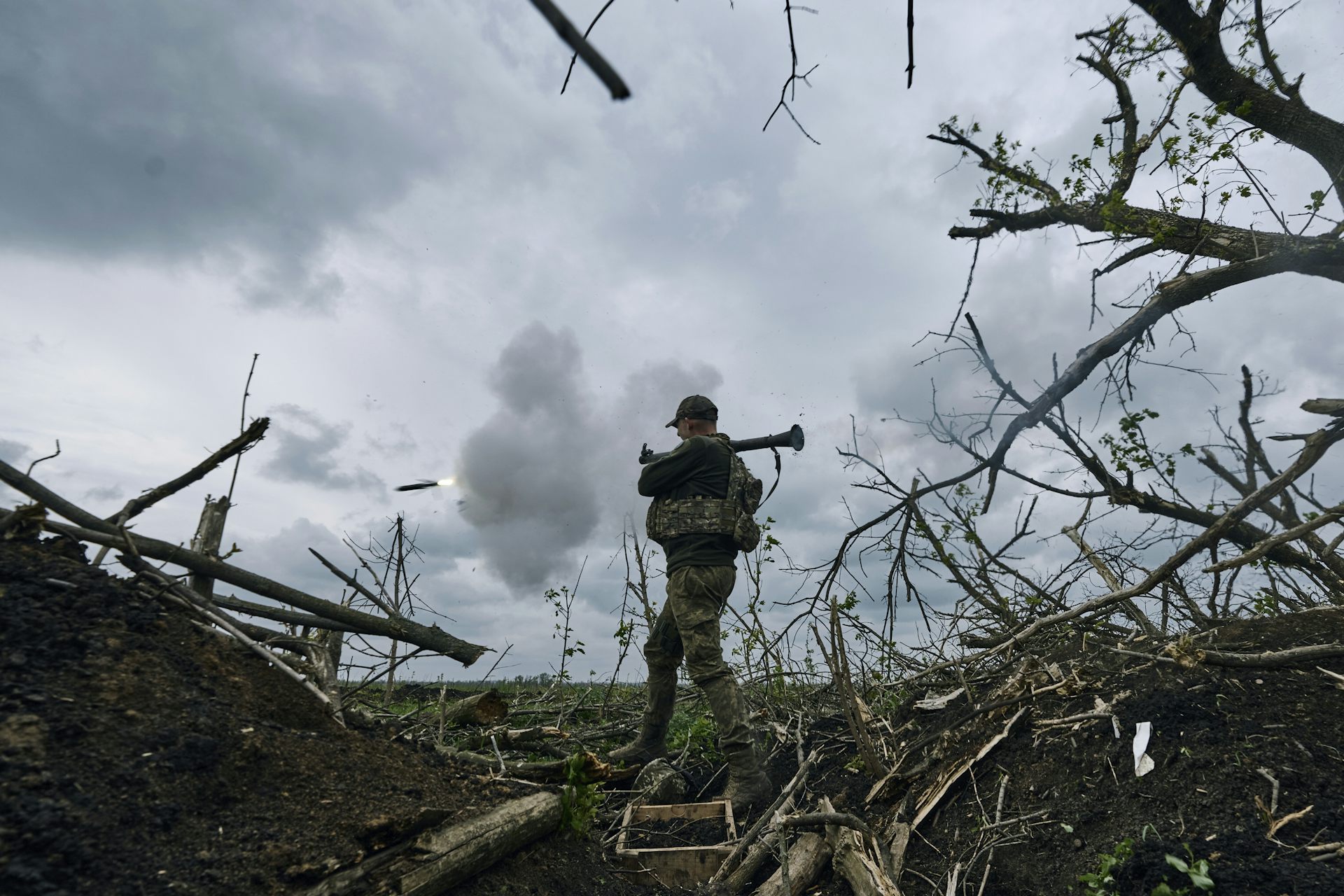 A Ukrainian soldier fires an RPG toward Russian positions in eastern Ukraine