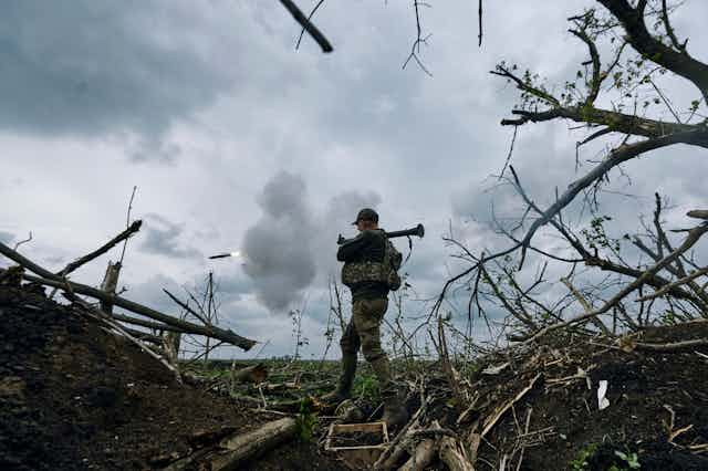 A Ukrainian soldier fires an RPG toward Russian positions in eastern Ukraine