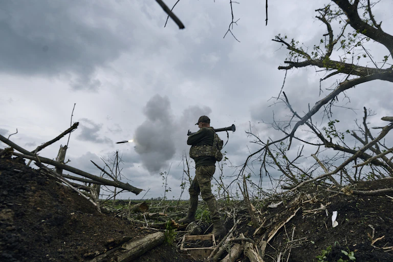 A Ukrainian soldier fires an RPG toward Russian positions in eastern Ukraine
