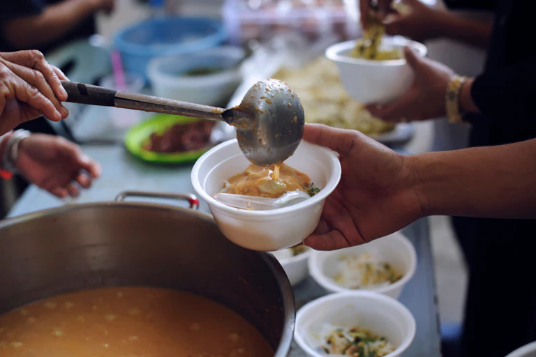Dishing out soup at soup kitchen