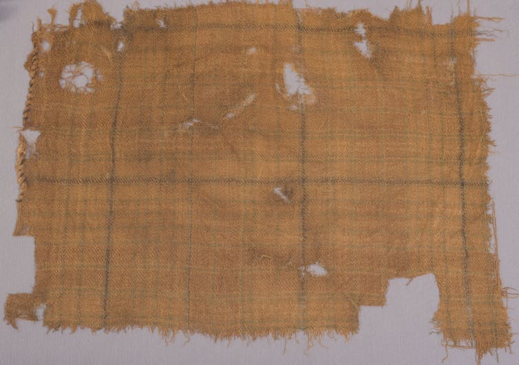A yellow scrap of tartan in a display case