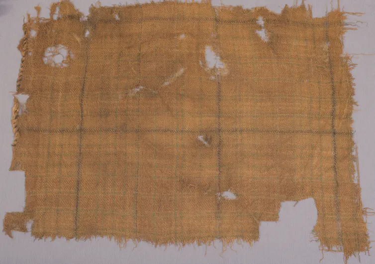 A yellow scrap of tartan in a display case