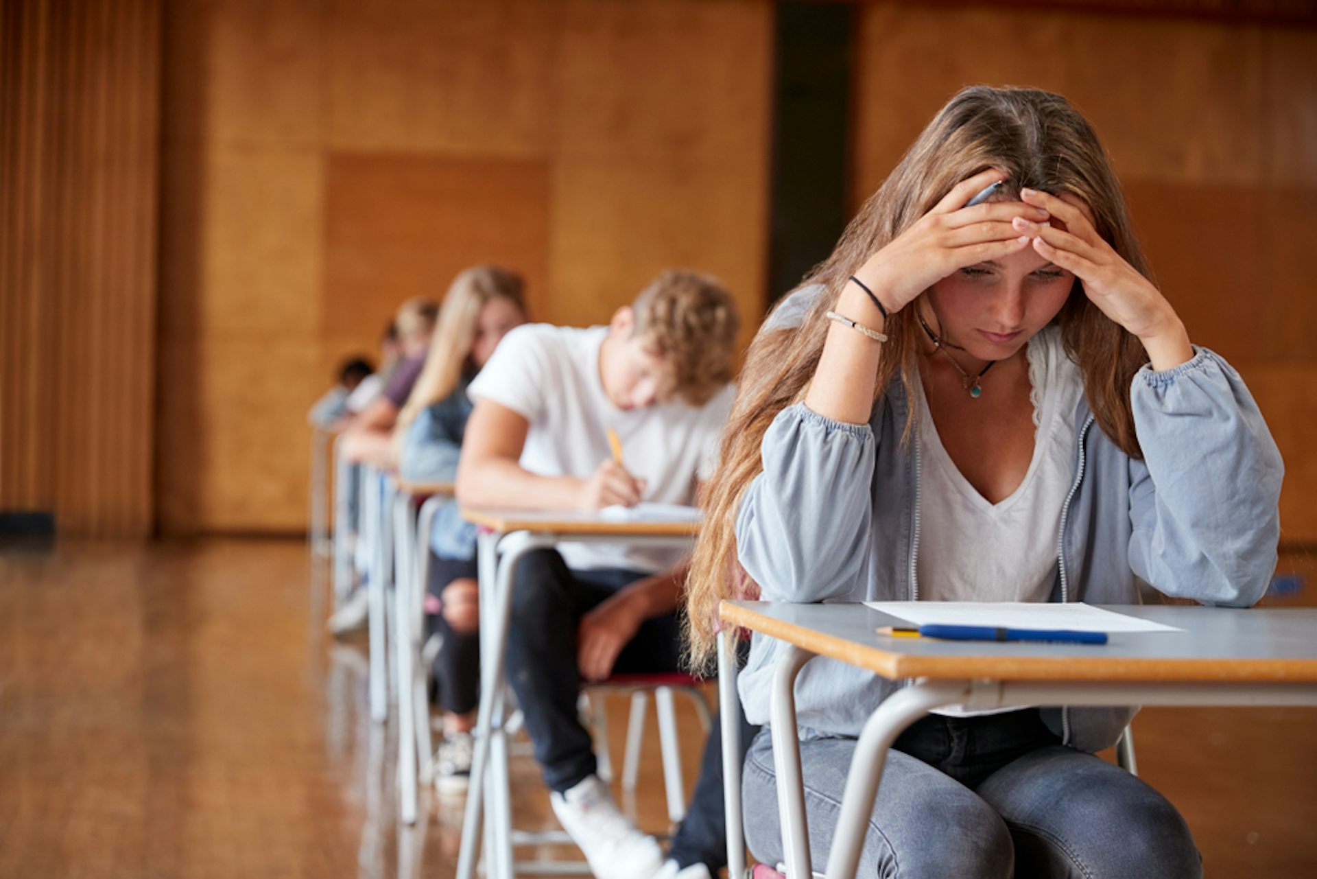 Une adolescente anxieuse lit un sujet dans la salle d’examen