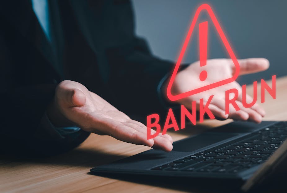 Person in suit at laptop with "Bank Run" and a warning symbol in red superimposed over their hands.