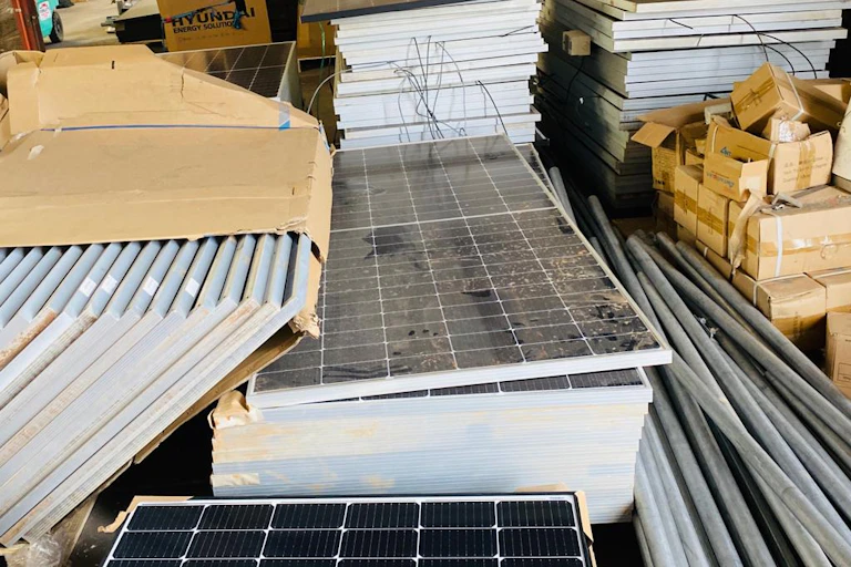 Old solar panels stacked up in piles