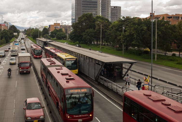 A rapid bus transit station next to lanes of traffic in Bogota, Colombia
