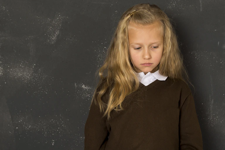 Little girl in front of blackboard