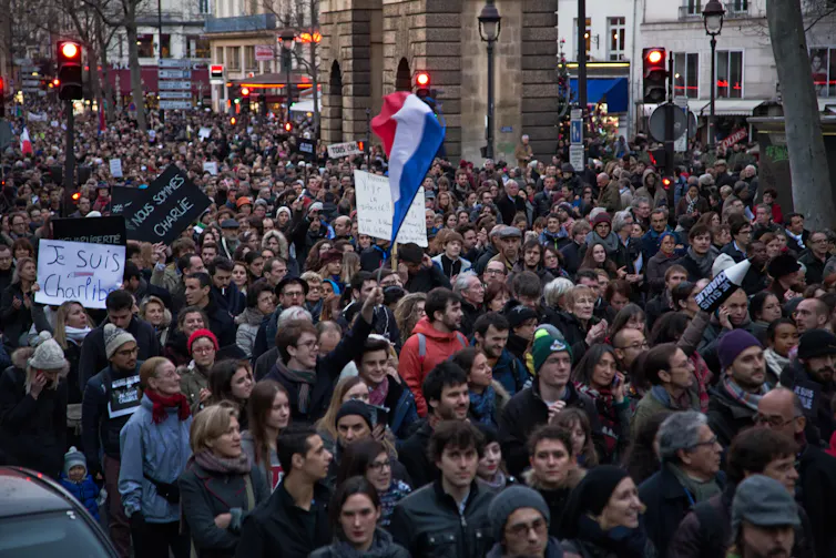 Protestors hold up posters and flags.