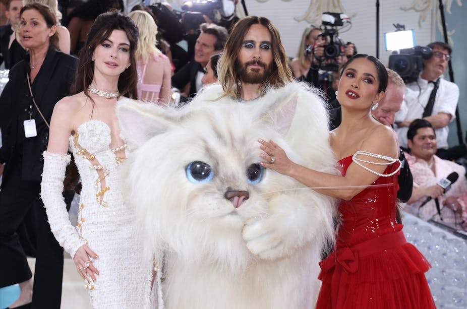 Anne Hathaway in a white dress, Jared Leto in his white cat costume and Salma Hayek in a red dress with pearl sleeves. 