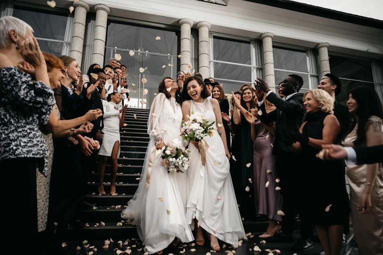 A female couple walking down the stairs during their wedding ceremony.