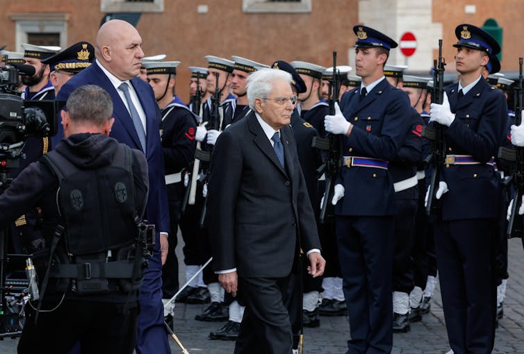 Ο Σέρτζιο Ματαρέλα περπατά μπροστά από στρατεύματα που στέκονται προς προσοχή.