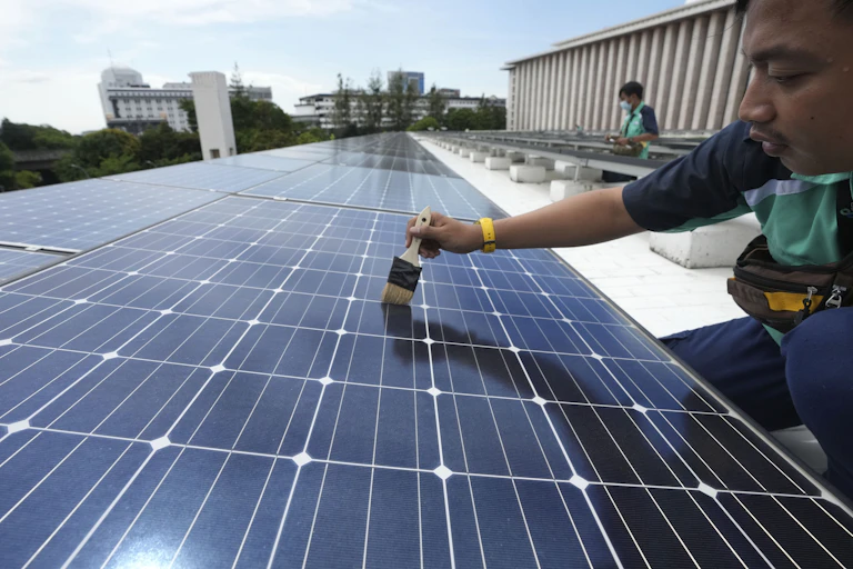 Man uses brush on solar panel