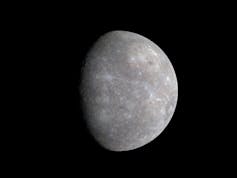An image of Mercury - a partially obscured dark grey sphere with lots of texture created by many craters on its surface, on a black background