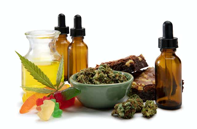 Gominolas de cannabis, brownies y diversos productos cannábicos en cuencos, tarros y botellas.